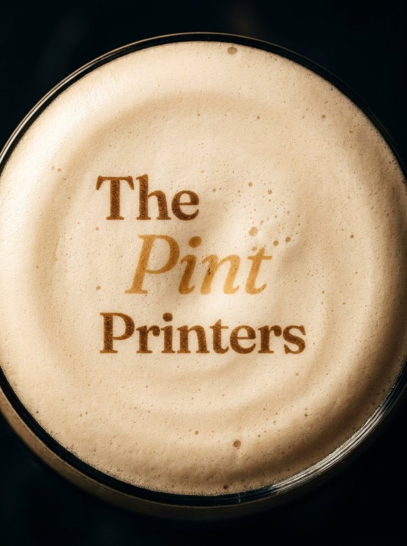 A pint of Guinness with The Pint Printers logo printed on the foam head