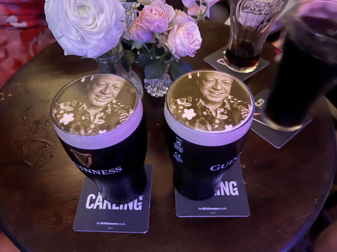 Two pints of Guinness with a guest photo printed on the foam at a wedding